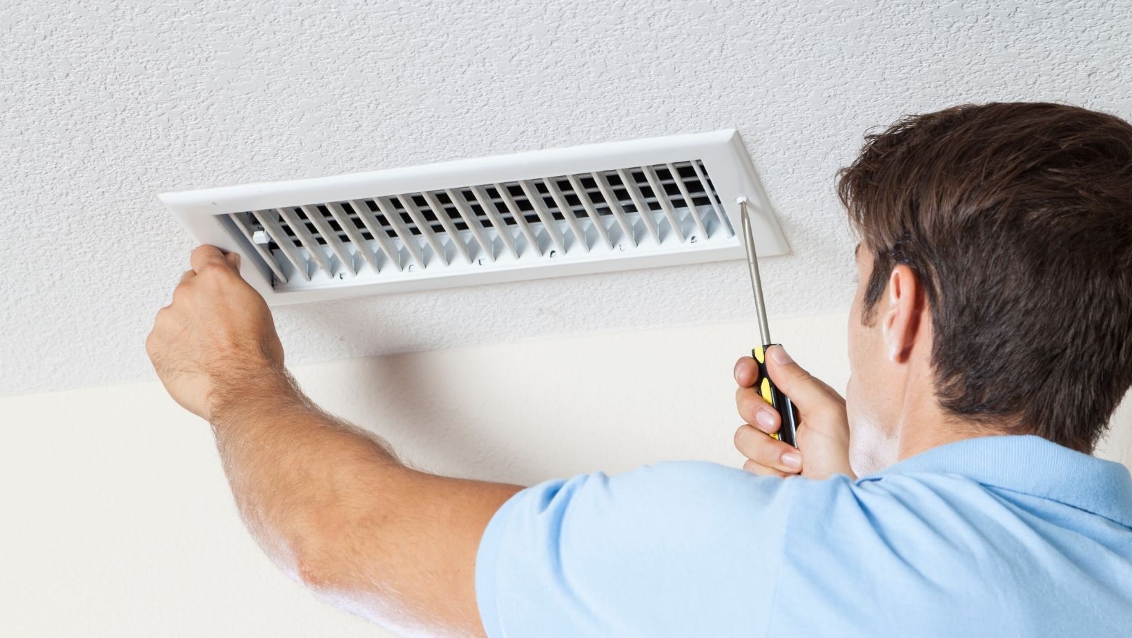 Technician inspecting and repairing an air duct vent, emphasizing HVAC maintenance and air quality management.