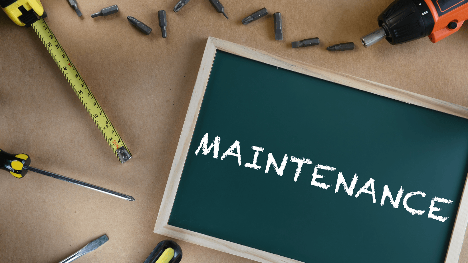 Tools for HVAC maintenance including a measuring tape, screwdriver, and chalkboard with "MAINTENANCE" written, emphasizing the importance of regular care for HVAC systems.