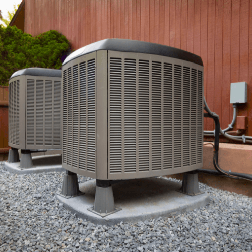 Heat pumps installed outside a home, highlighting energy efficiency and HVAC systems.