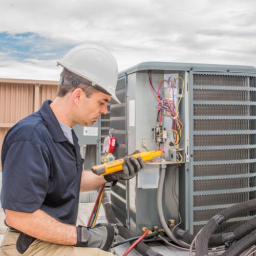 HVAC technician inspecting air conditioning unit with multimeter, ensuring proper functionality and maintenance.