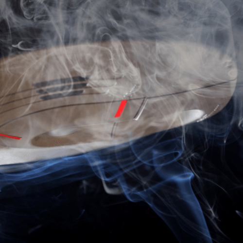 Duct-mounted smoke detector emitting smoke, illustrating its role in HVAC systems for smoke detection and prevention of smoke circulation.