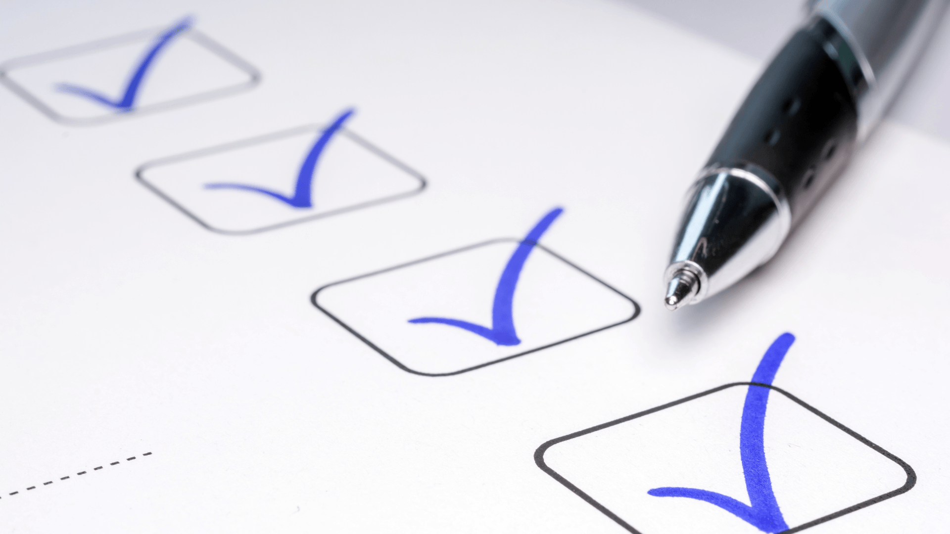 Checklist with blue check marks and a pen, symbolizing DIY maintenance tasks for HVAC systems.