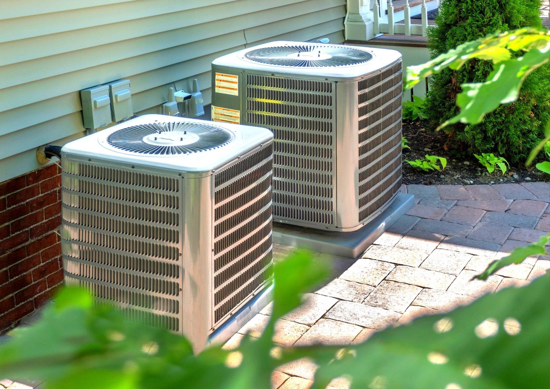 HVAC units installed outside a home, showcasing heat pumps and energy-efficient cooling systems, relevant to residential HVAC services and system selection.