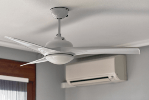 Ceiling fan in a room with an air conditioning unit, illustrating the importance of air circulation for HVAC efficiency and cooling comfort.
