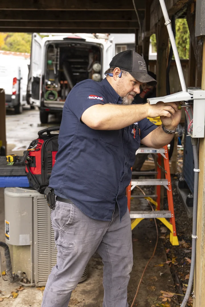 technician inspecting residential heat pump outdoor unit technician inspecting residential heat pump outdoor unit