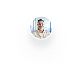 Smiling man in white shirt with short dark hair in front of windows.