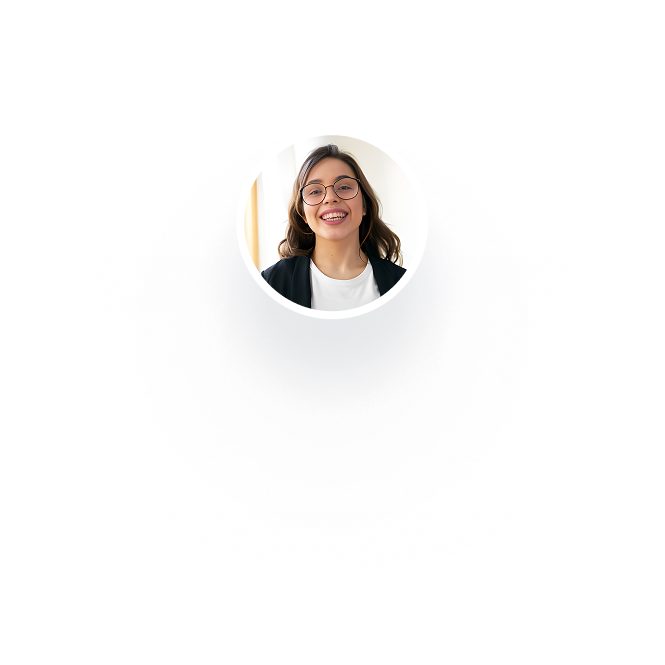 Smiling young woman with glasses, wearing a black blazer and white shirt, looking at the camera.