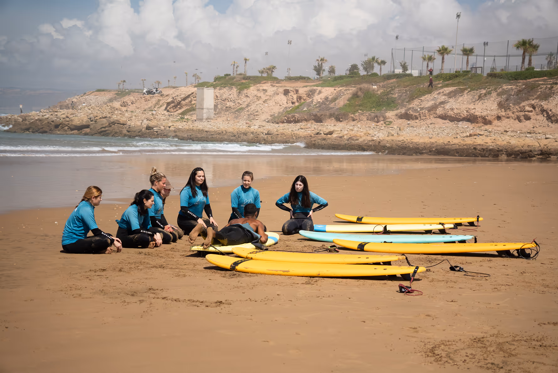 Surf coaching team with surfboards on the beach in Tamraght, Morocco – Salt House Surf Camp