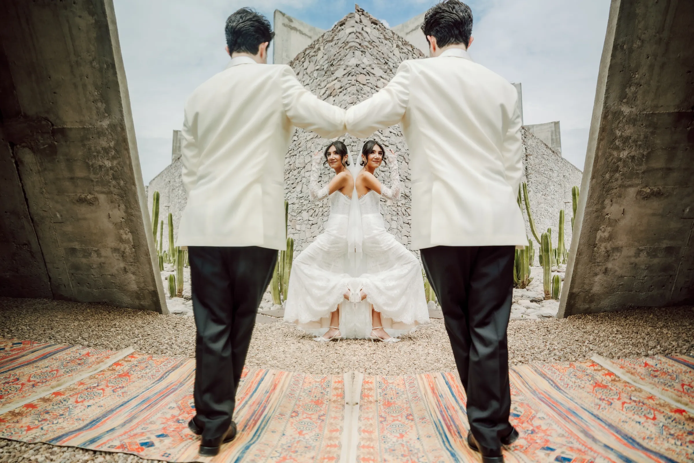 Reflejo de los novios en un espejo entre arquitectura de concreto y cactus