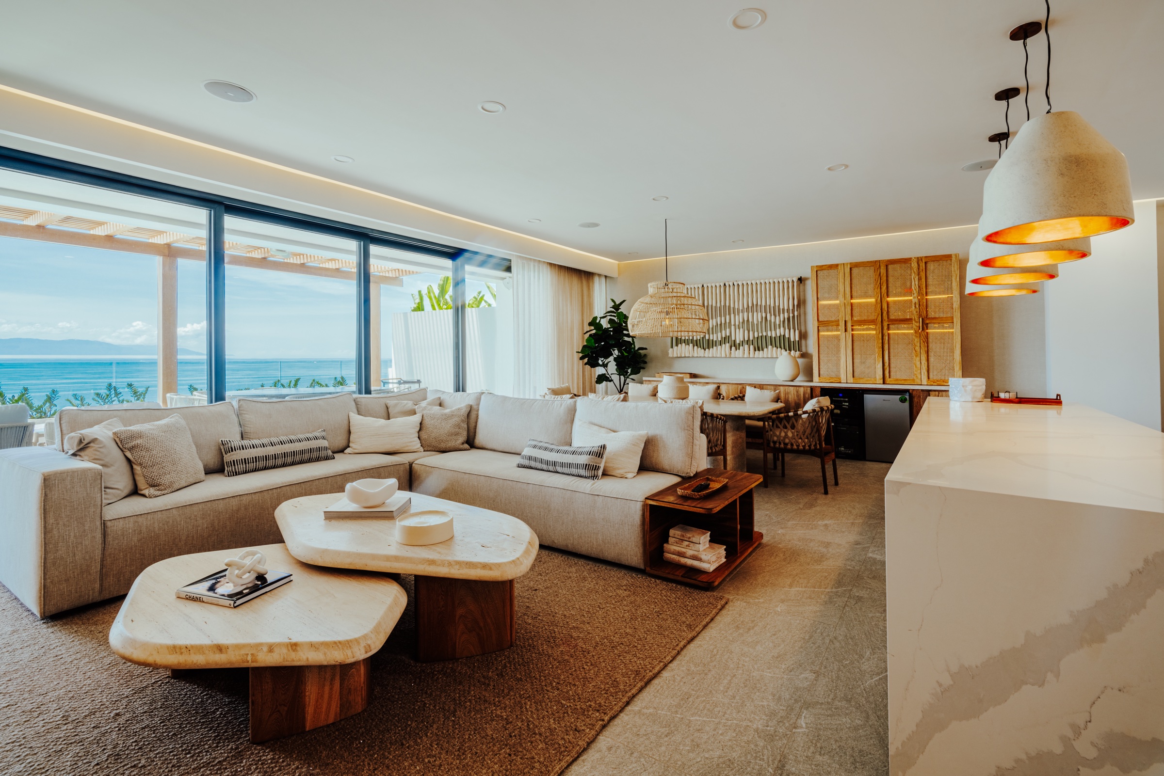 fotografía de interiores de una sala con ventanales y vista al mar
