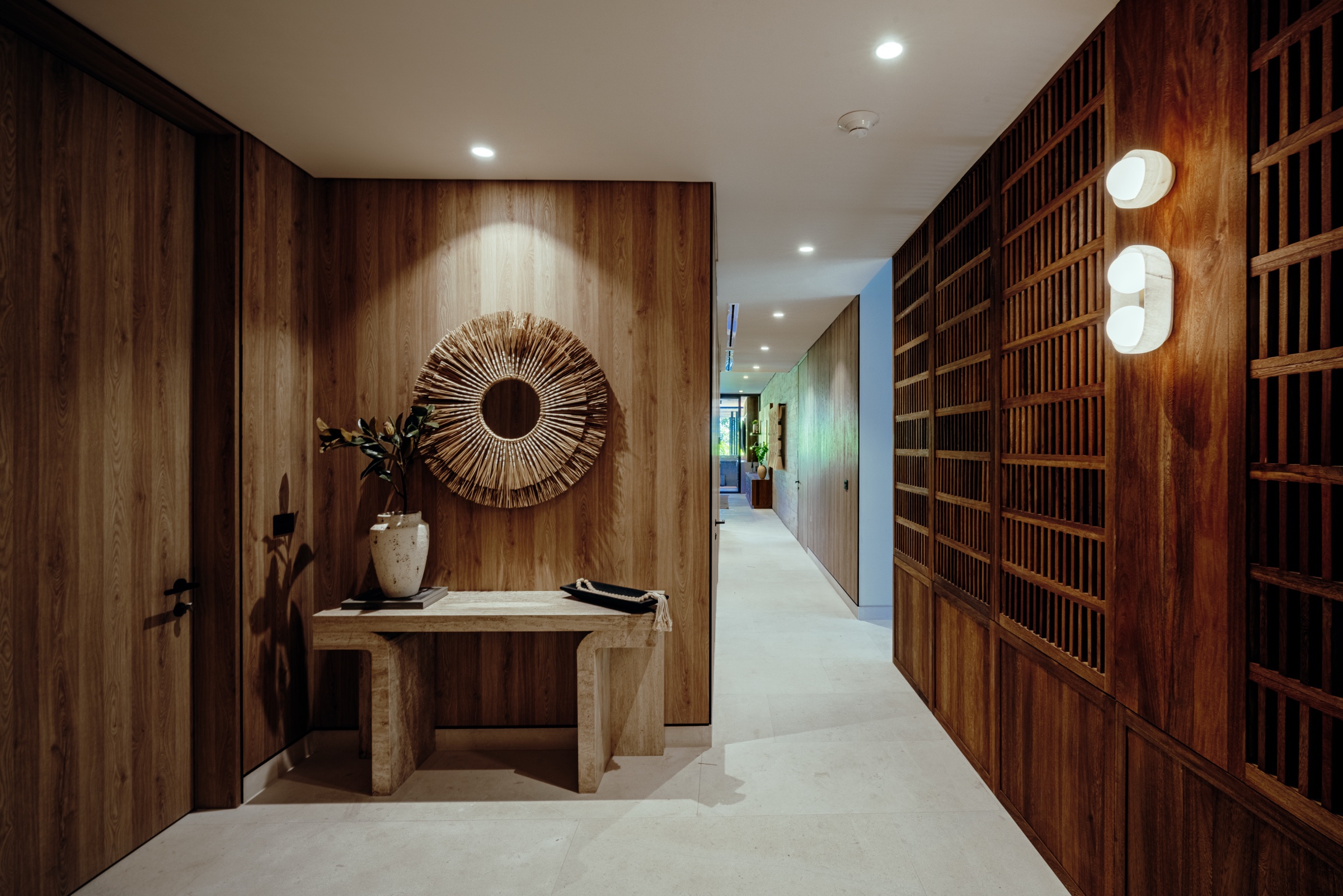 pasillo interior con revestimiento de madera y espejo circular