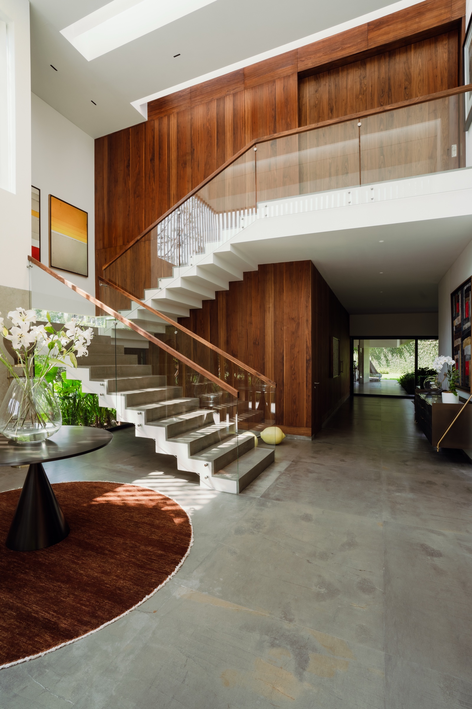 fotografía de arquitectura interior con escalera, barandal de cristal y muros de madera