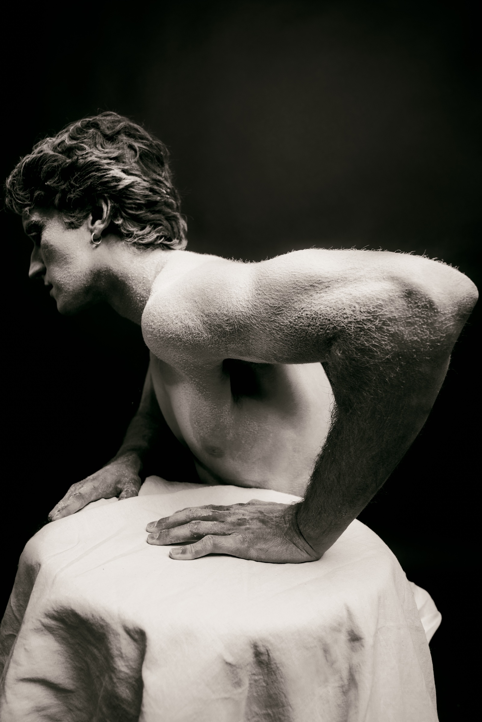 retrato editorial en blanco y negro de un hombre apoyado sobre una mesa