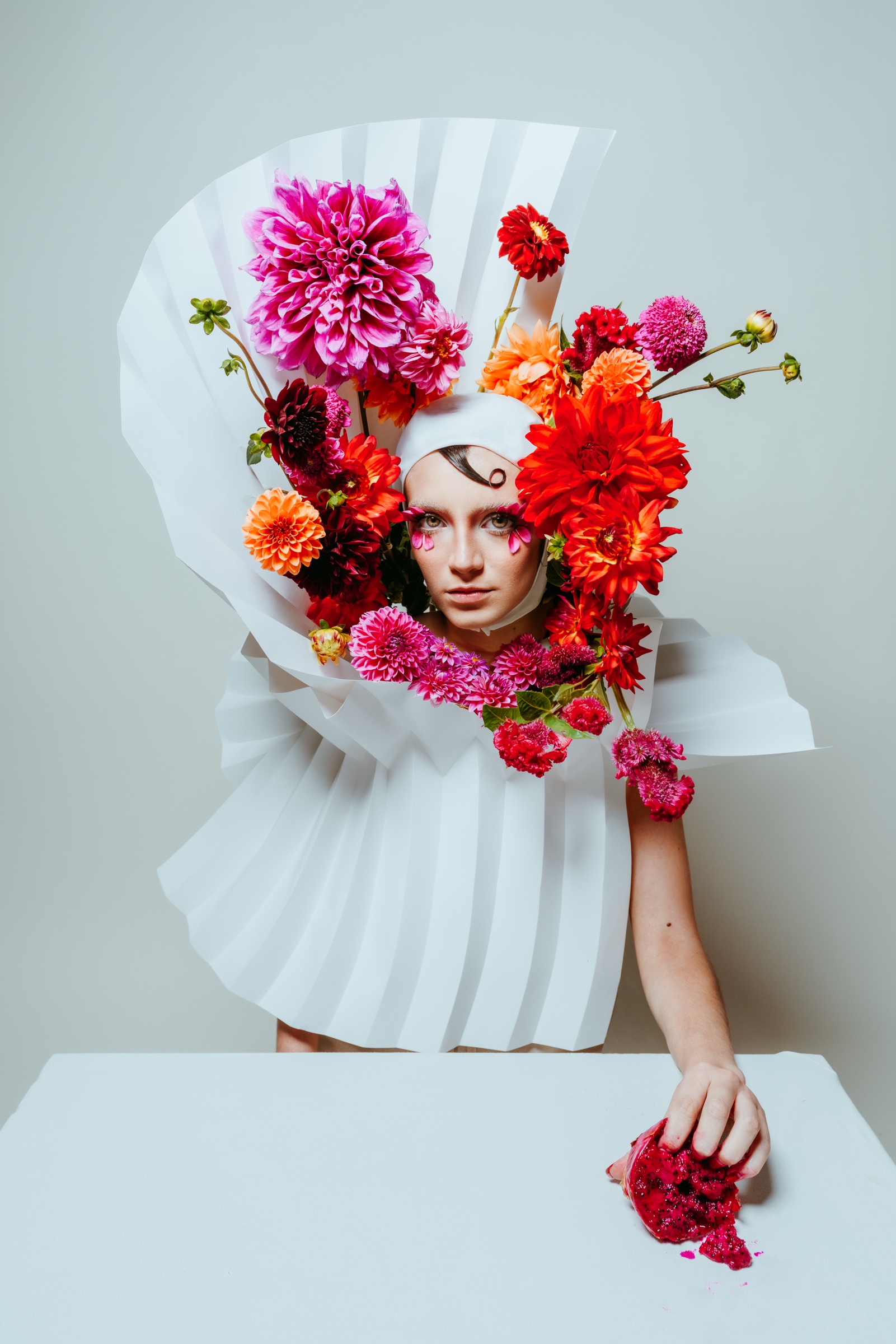 retrato editorial con flores de colores y estructura de papel blanco