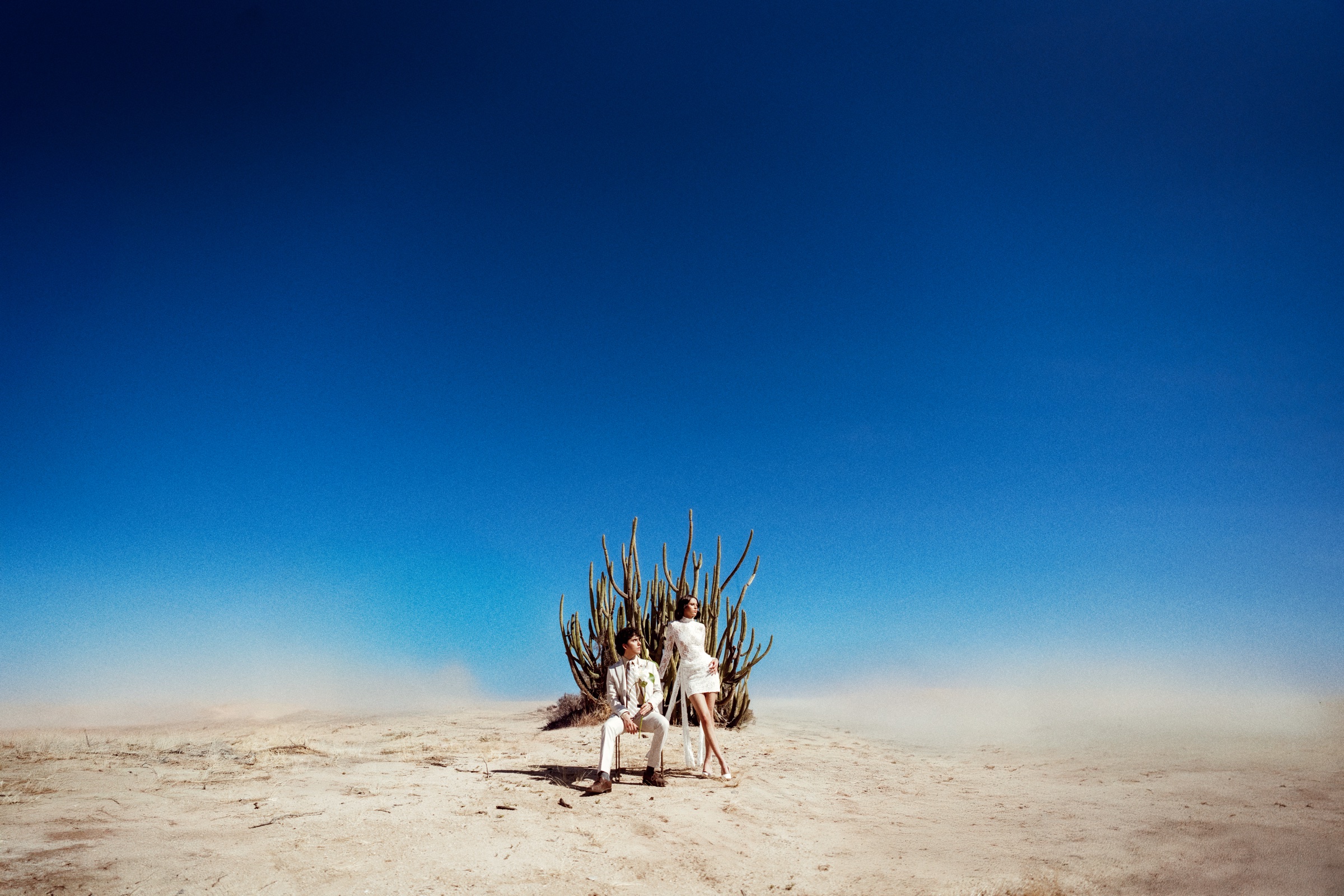 fotografía editorial de dos personas vestidas de blanco junto a un cactus