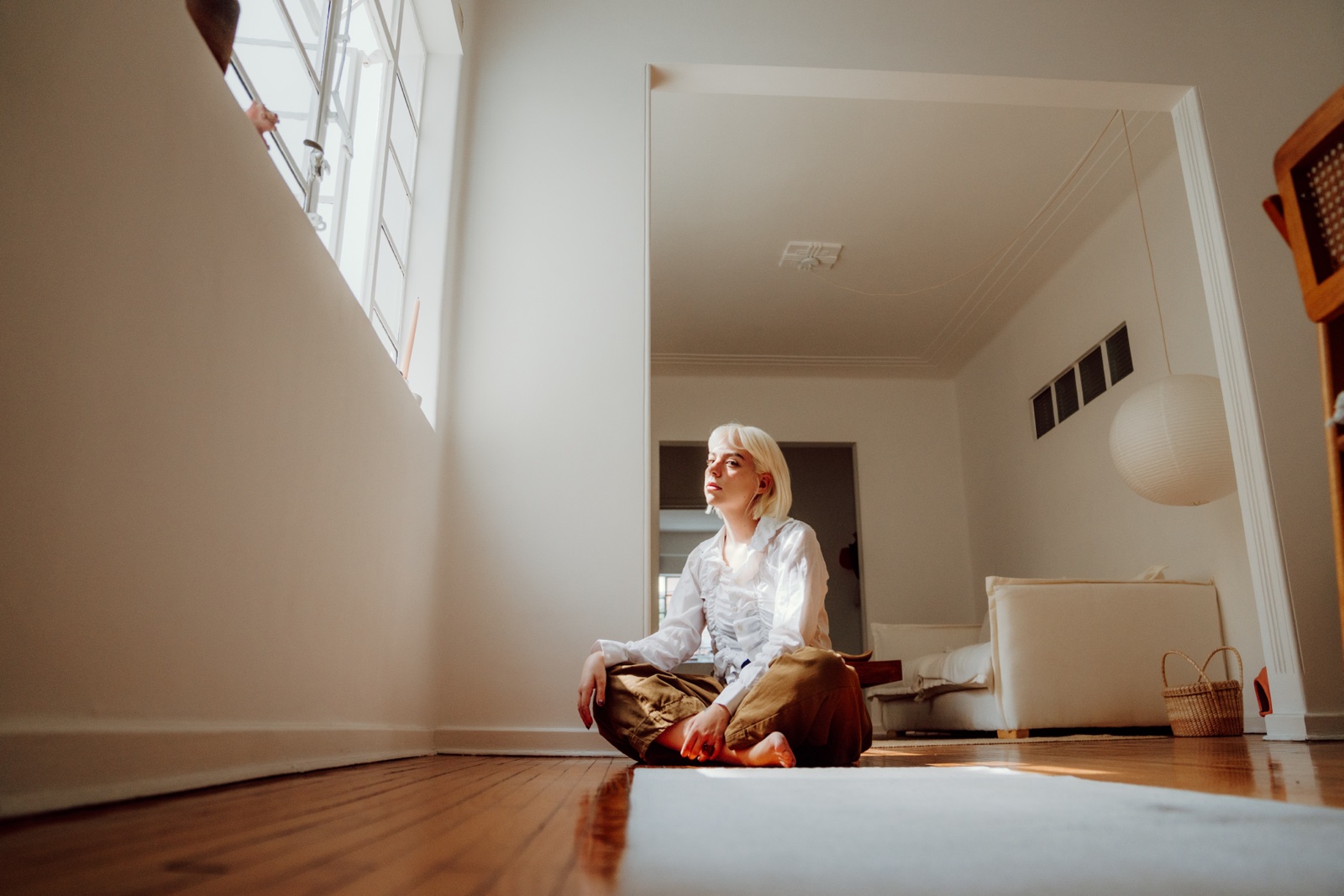retrato de una mujer sentada en el piso junto a una ventana