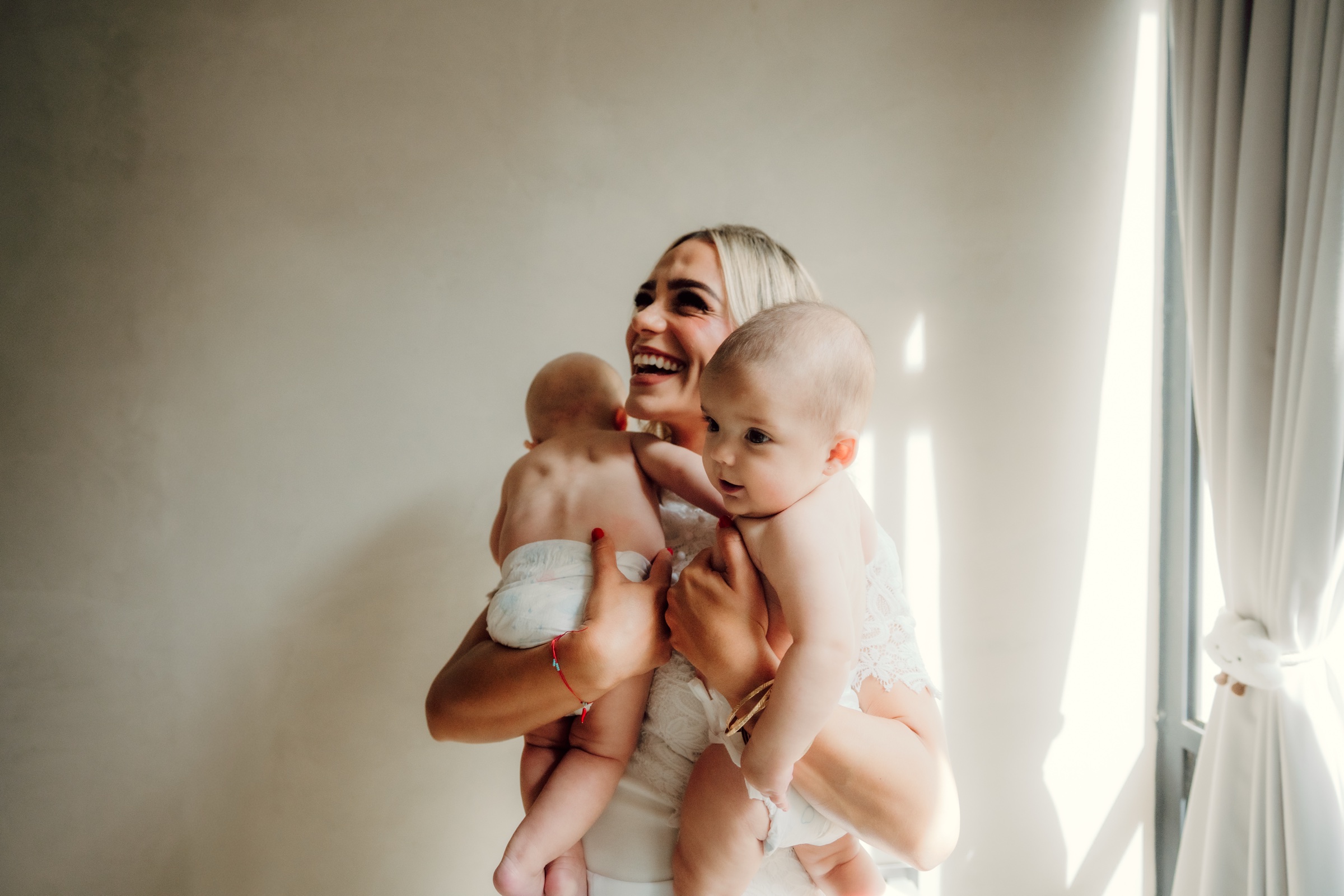 retrato familiar de una mujer abrazando a dos bebés