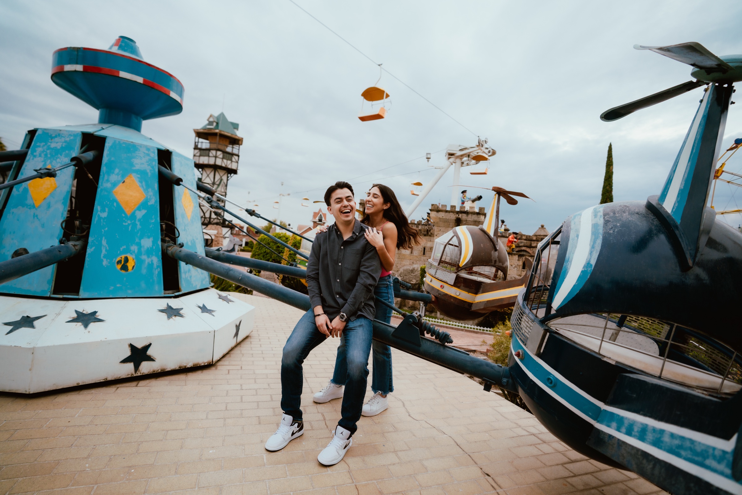 sesión de pareja junto a juegos de un parque de diversiones