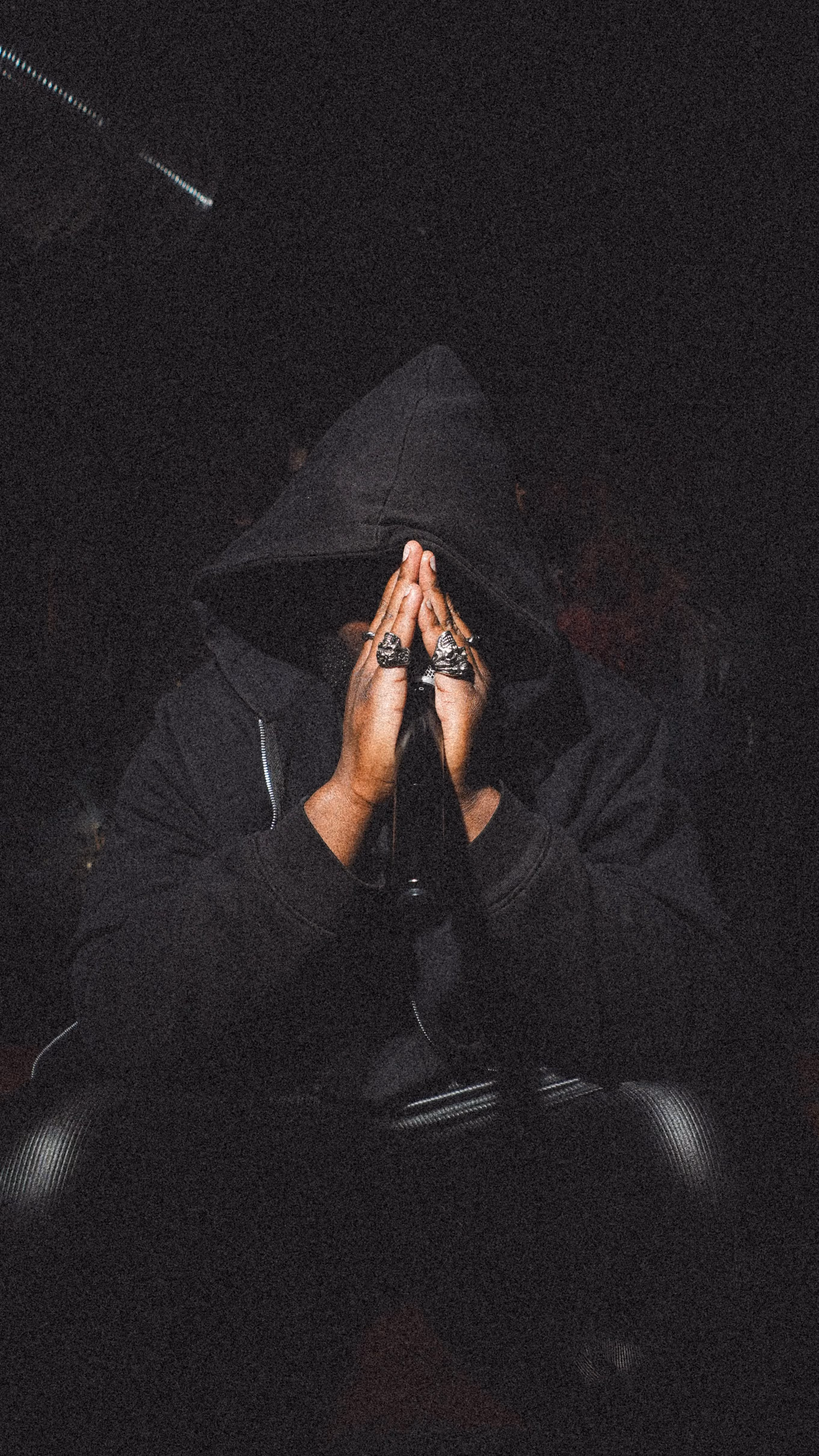 Portrait de LBH, capuche noire et mains jointes