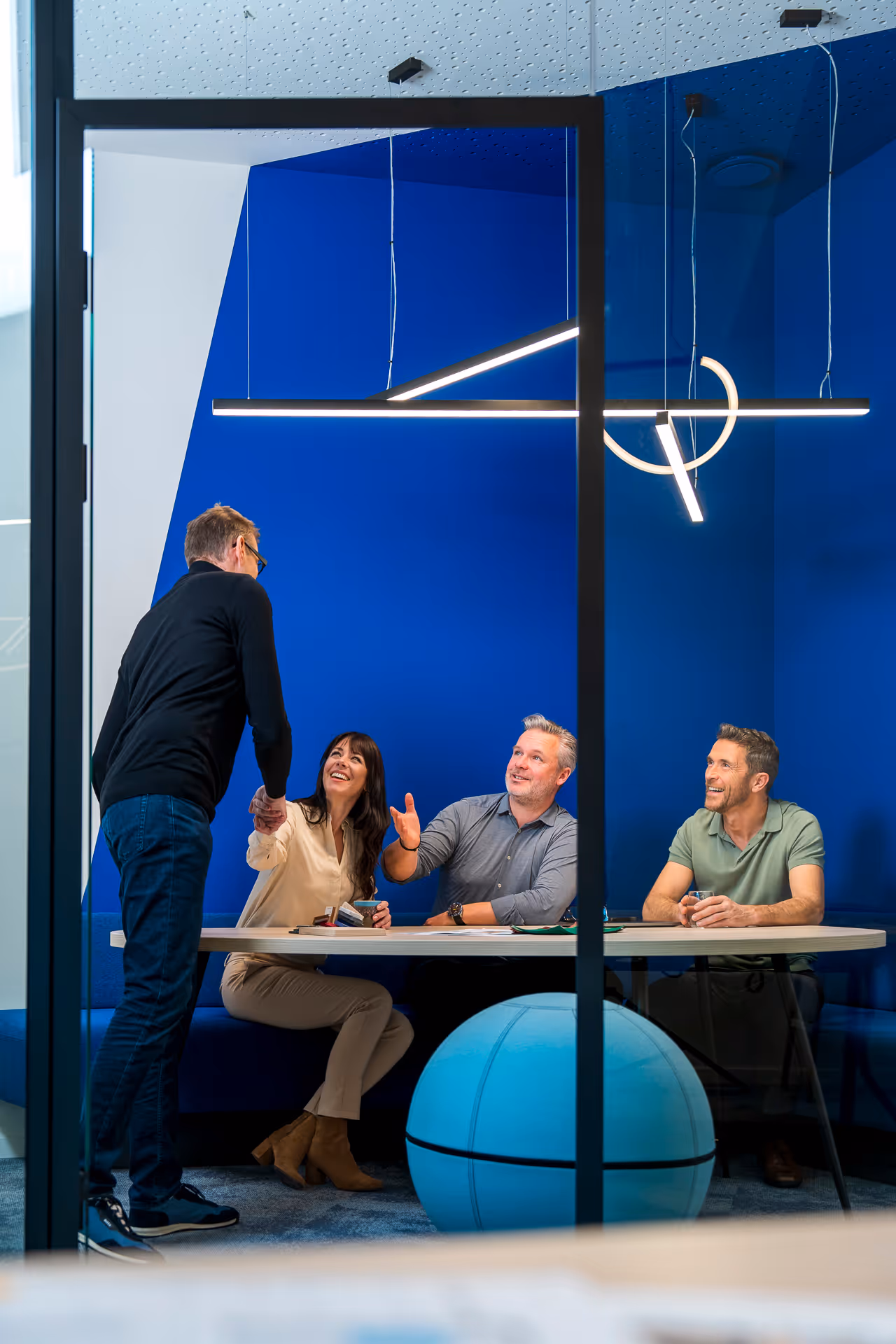 Medewerkers van Studio Dar schudden de hand in afgesloten vergaderruimte.