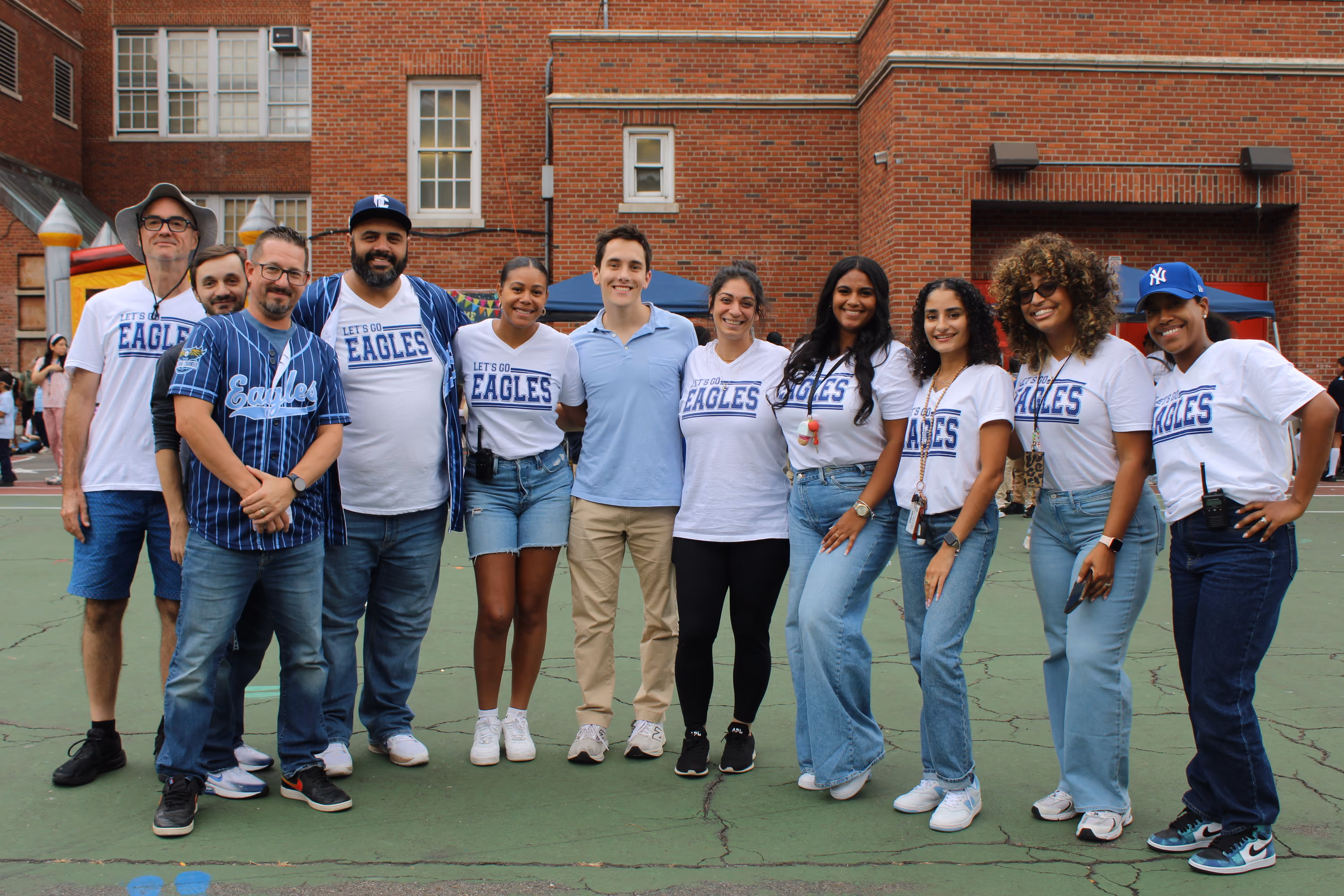 Staff and students in Let's Go Eagles shirts at a school event
