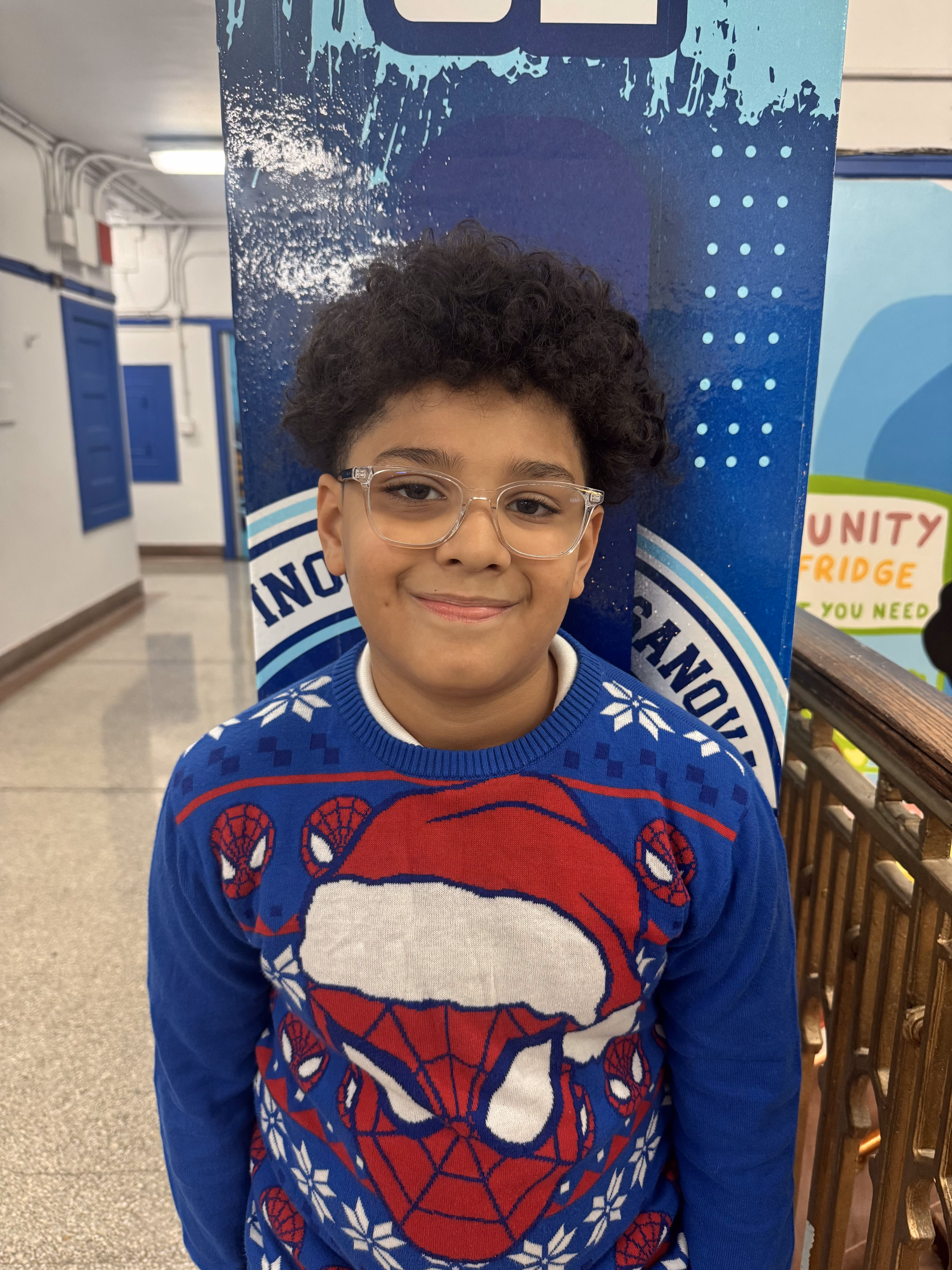 Student wearing a Spider-Man holiday sweater smiling at school