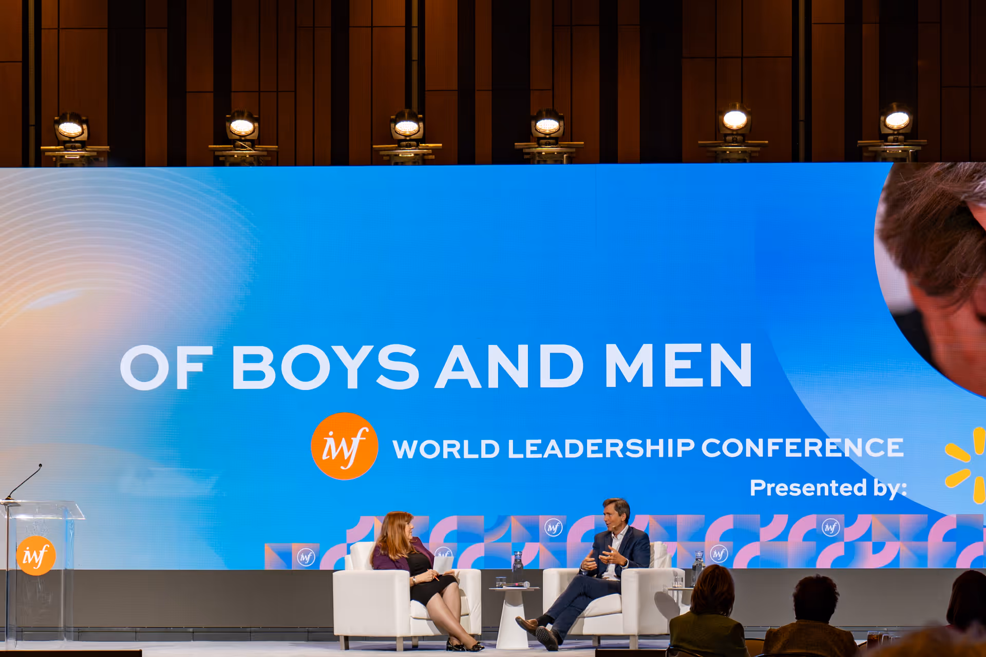 A stage with two speakers at the International Women's Forum.