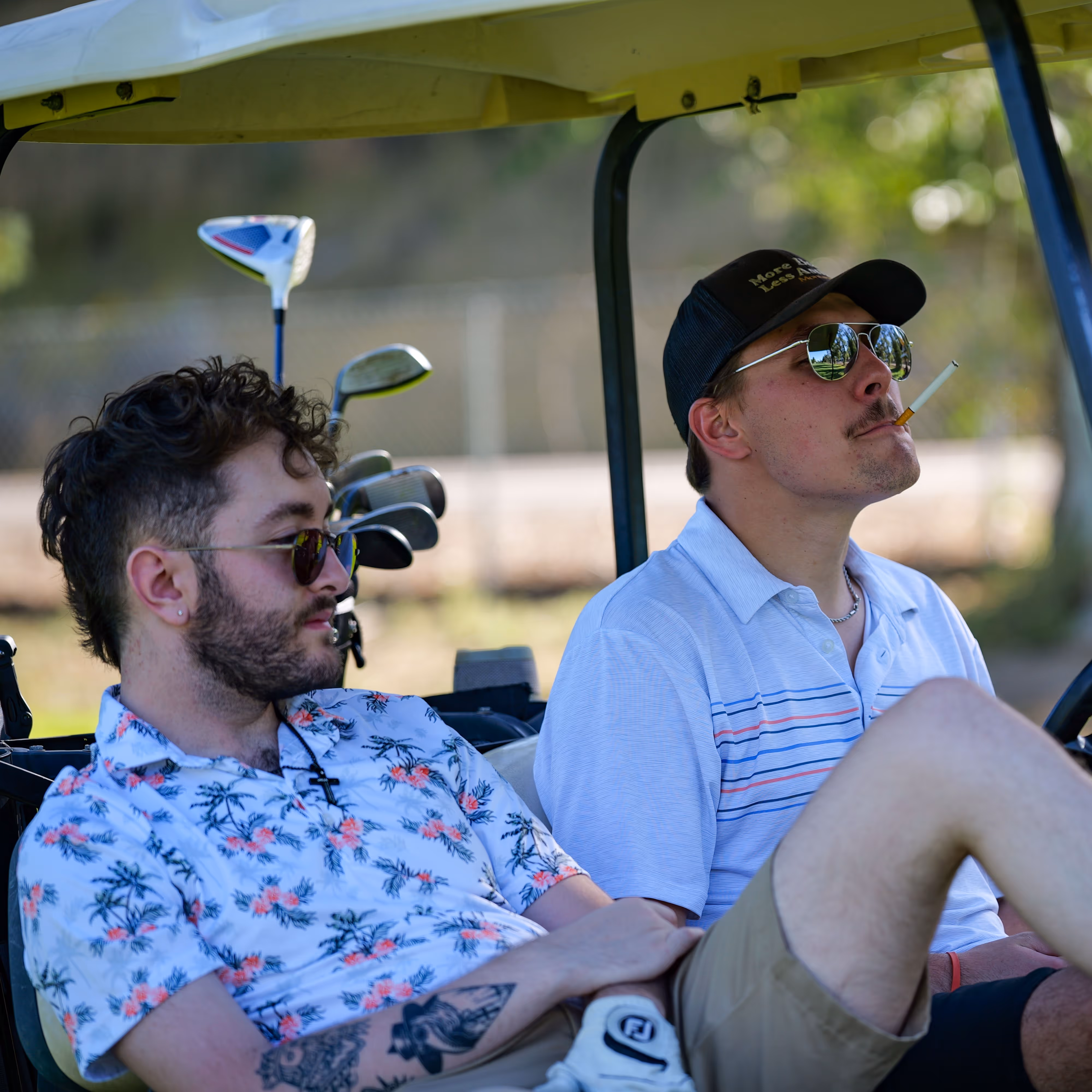 A golfer smoking a cigarette in a golf cart.