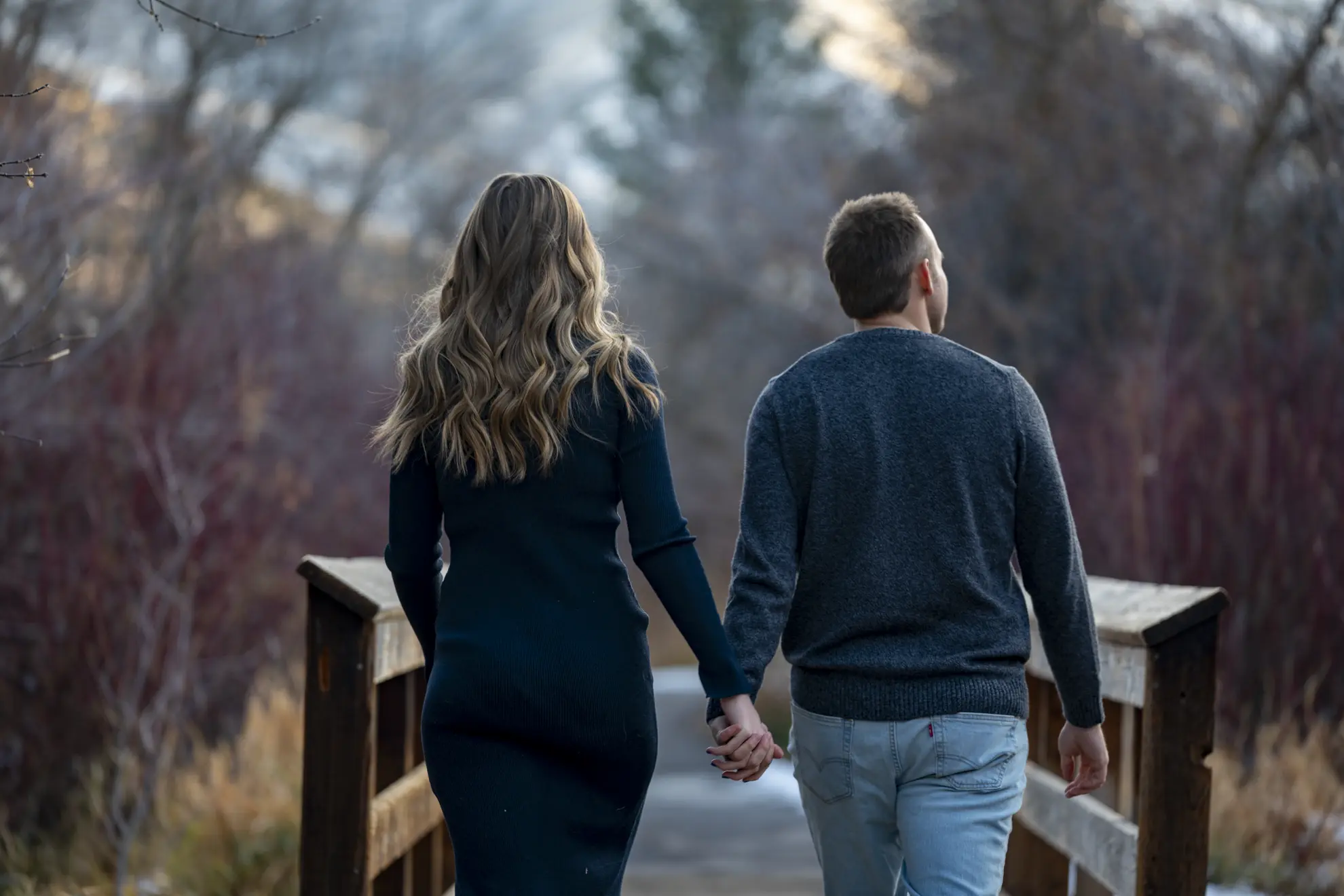A couple walking on a bridge.