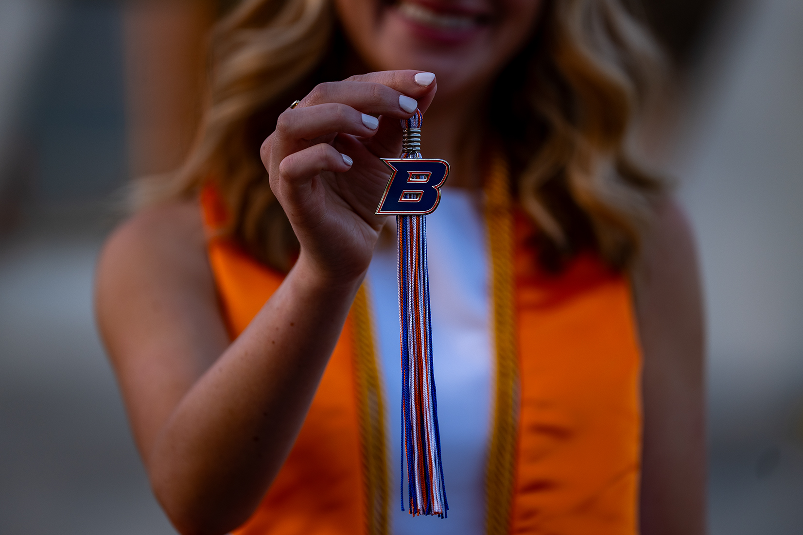 A Boise State graduate holding up her tassel