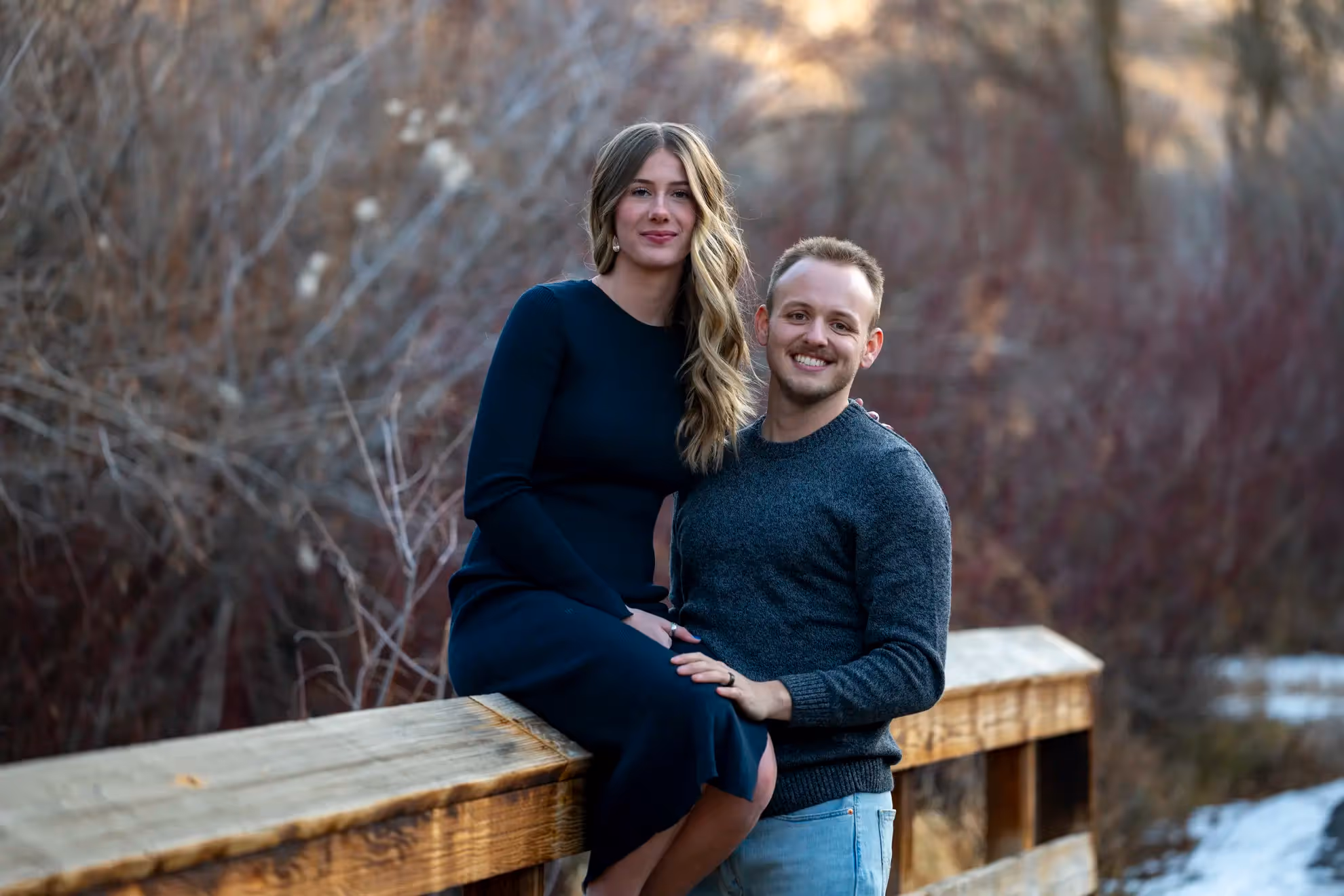 A newly engaged couple on a bridge.
