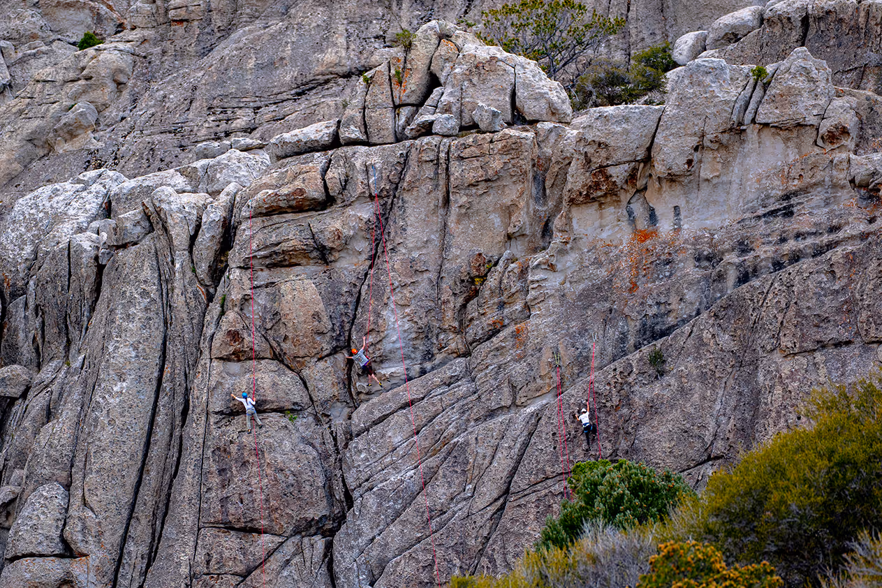 A group of climbers on the face of a massive rock at the City of Rocks