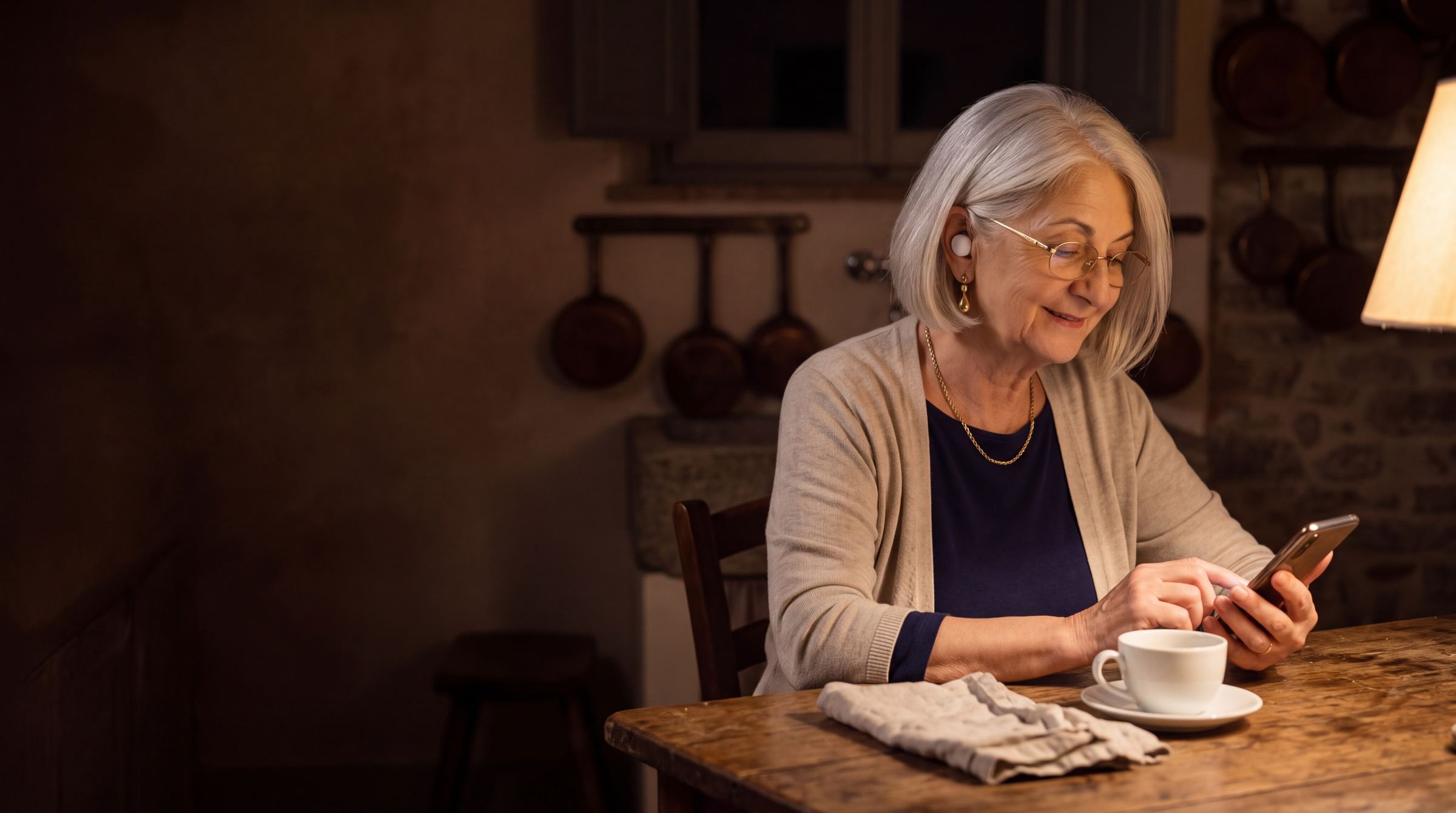 Zia Francesca at her kitchen table in the evening, listening through one earbud with her phone in her hands.