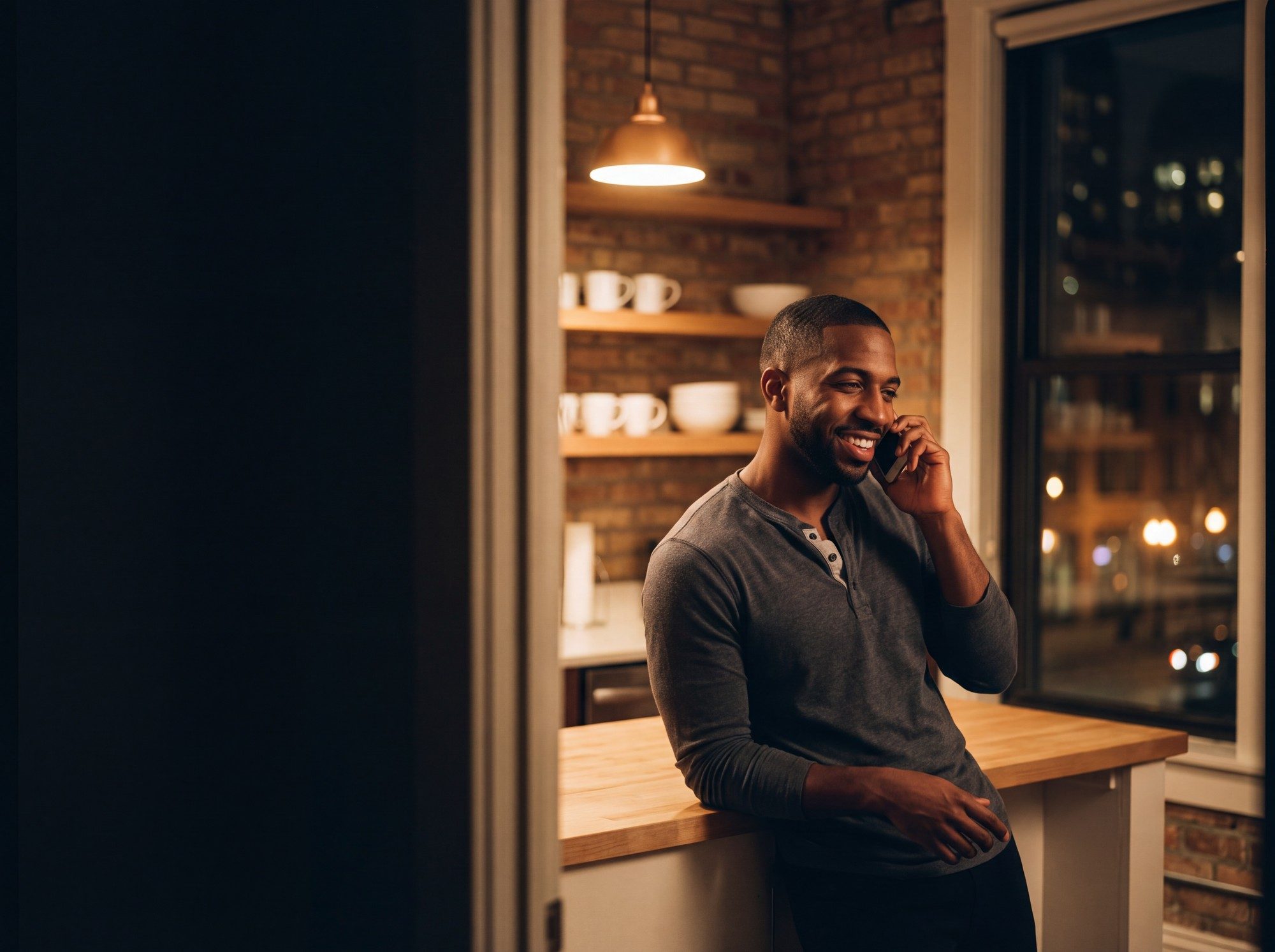 Marcus at home in Chicago at night, off duty, phone to his ear, smiling