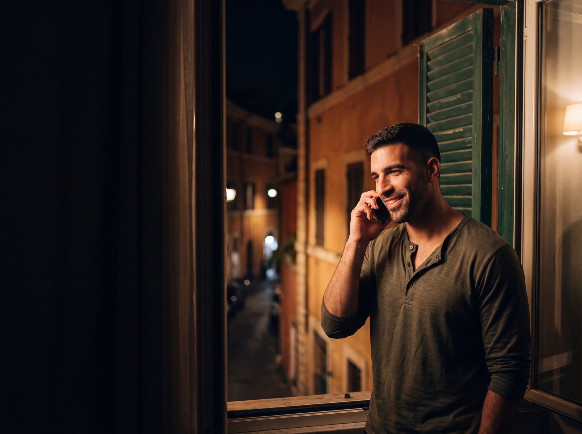 Luca at home in Rome at night, phone to his ear, smiling