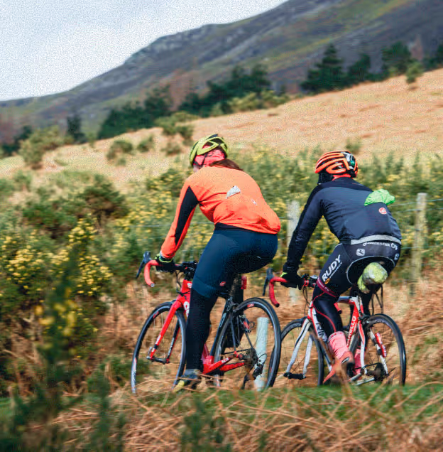Two people riding bike in mountains