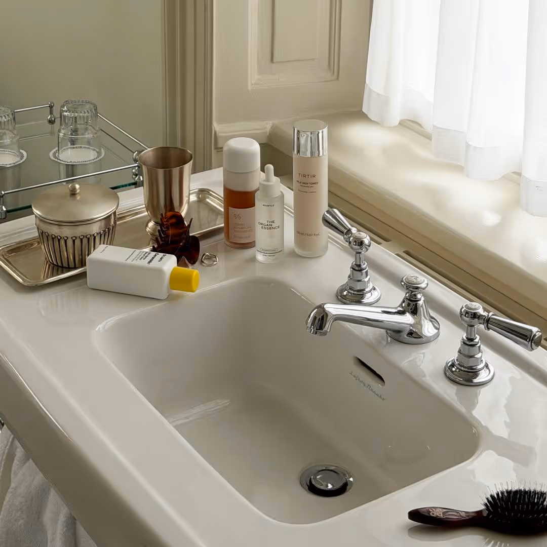 Fyra olika essence från Dr. Jart+, Dr. Ceuracle, Mantle och Tirtir står på kanten av ett handfat