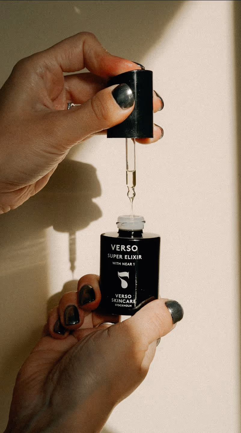 Hand som droppar Verso Super Elexir, ett hudvårdande serum med retinoider, ur en pipett