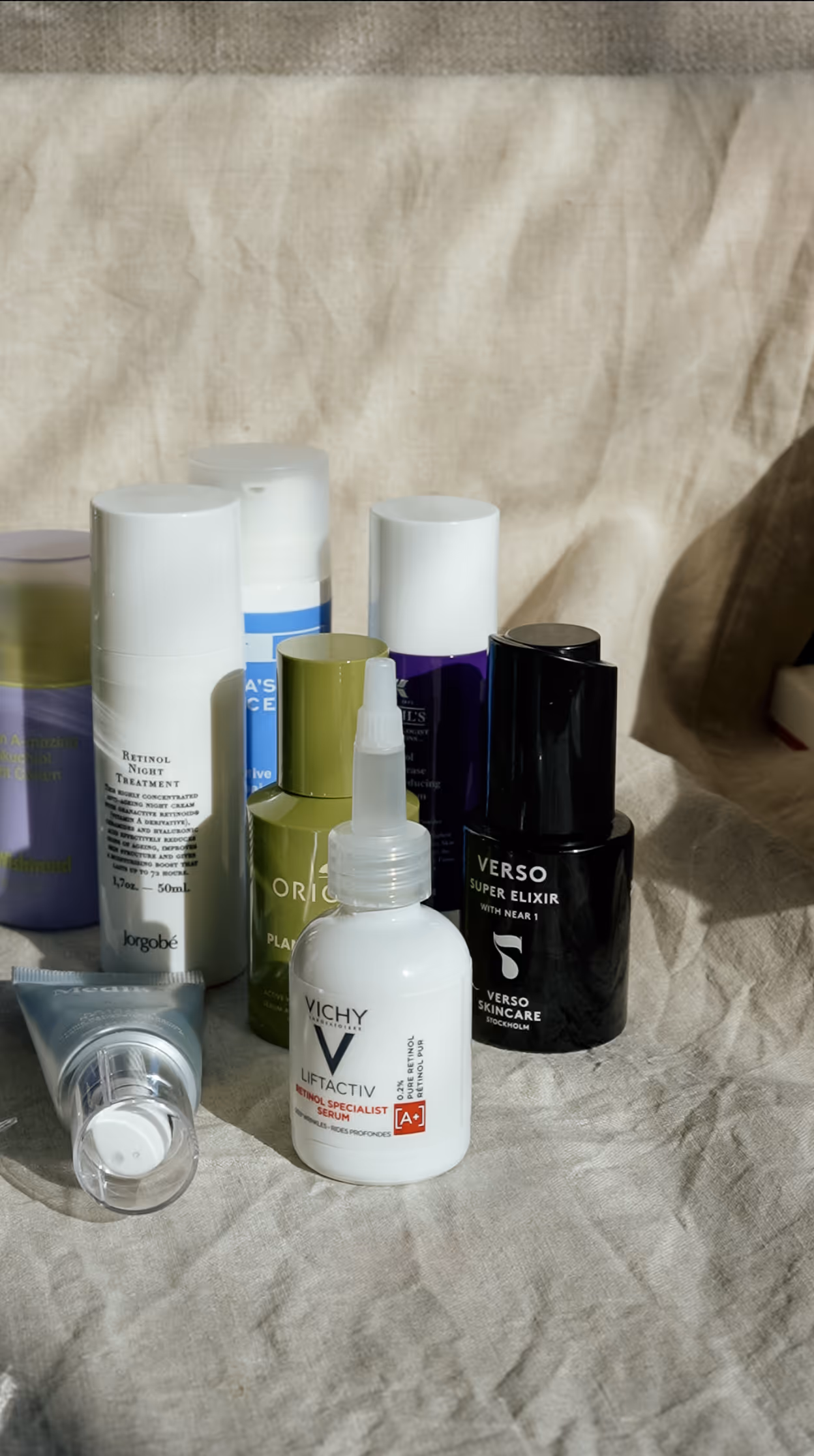 Flertalet hudvårdsprodukter i kategorin retinol står uppställda mot en beige bakgrund, bland annat från Vichy och Verso
