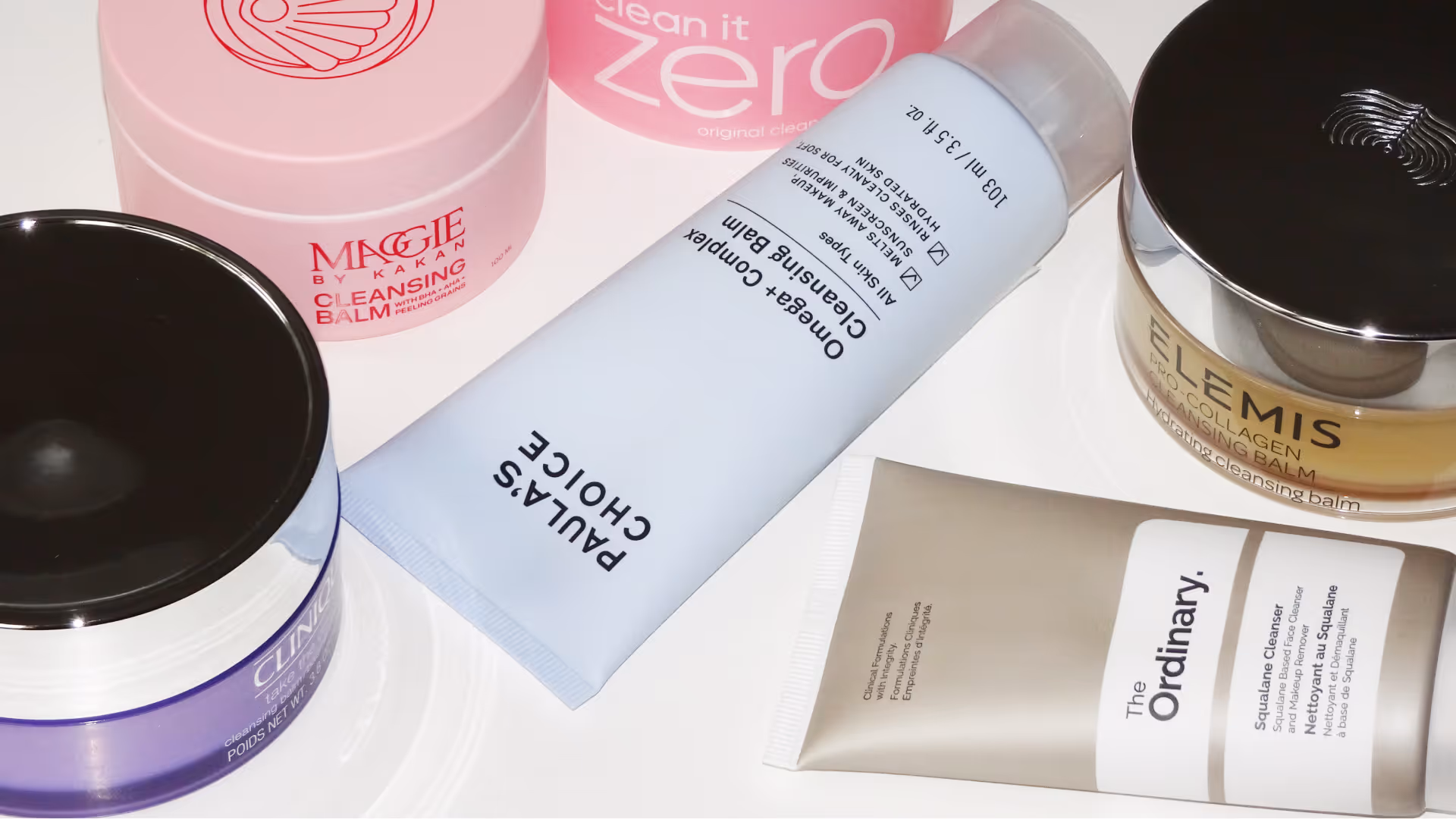 Oljerengöring produkter från Clinique, Maggie by Kakan, Paula’s Choice, The Ordinary, Banila Co och Elemis på vitt underlag.