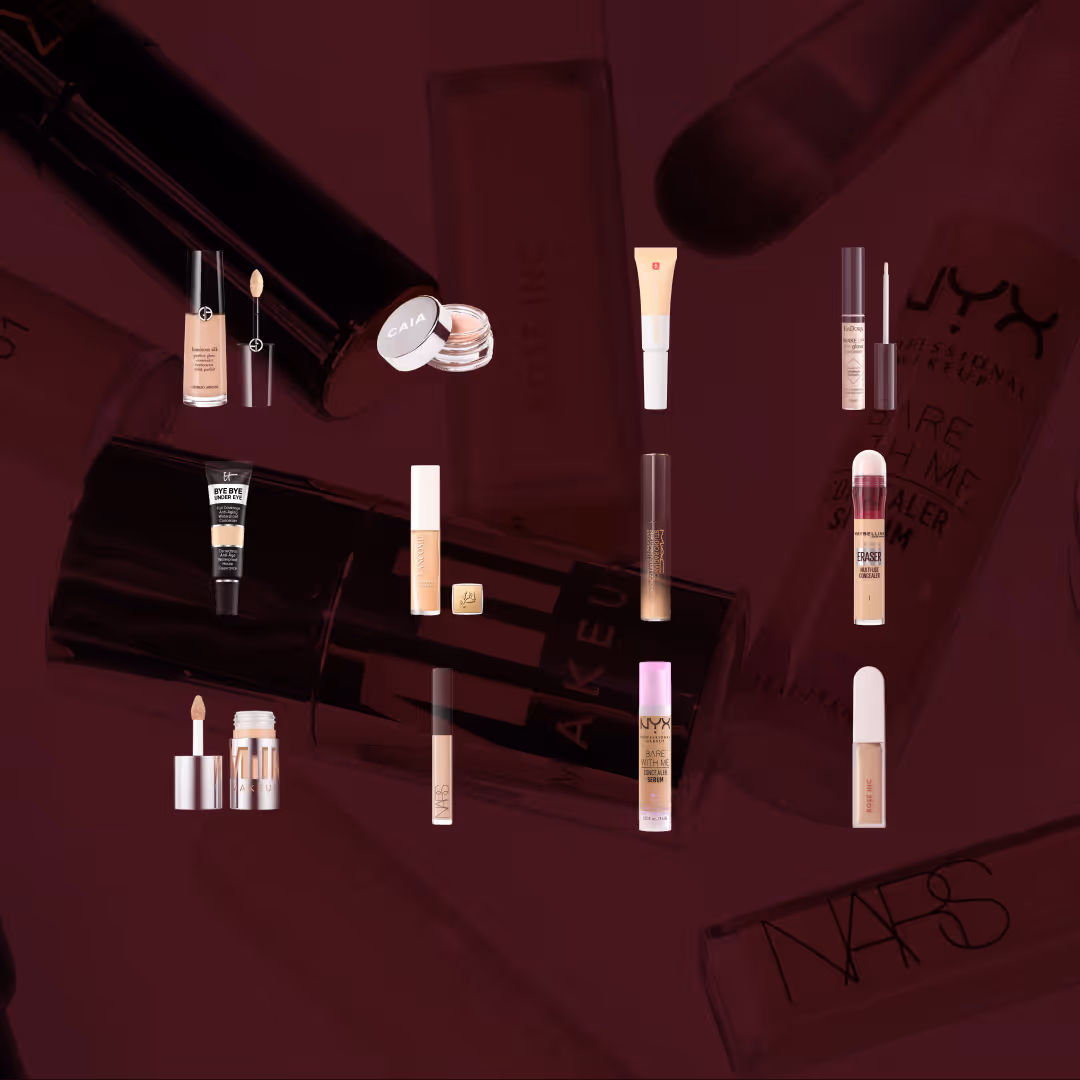 Alla testade produkter i vårt stora test av under eye-concealer. Elva olika concealerförpackningar från märken som Giorgio Armani, CAIA, IsaDora, Maybelline, NYX, NARS, IT Cosmetics, Lancôme, Rose Inc och Milk Makeup är placerade i två rader på en vinröd bakgrund. Förpackningarna har olika former, såsom tuber, burkar och flaskor med applikator. I bakgrunden syns suddiga versioner av samma produkter.