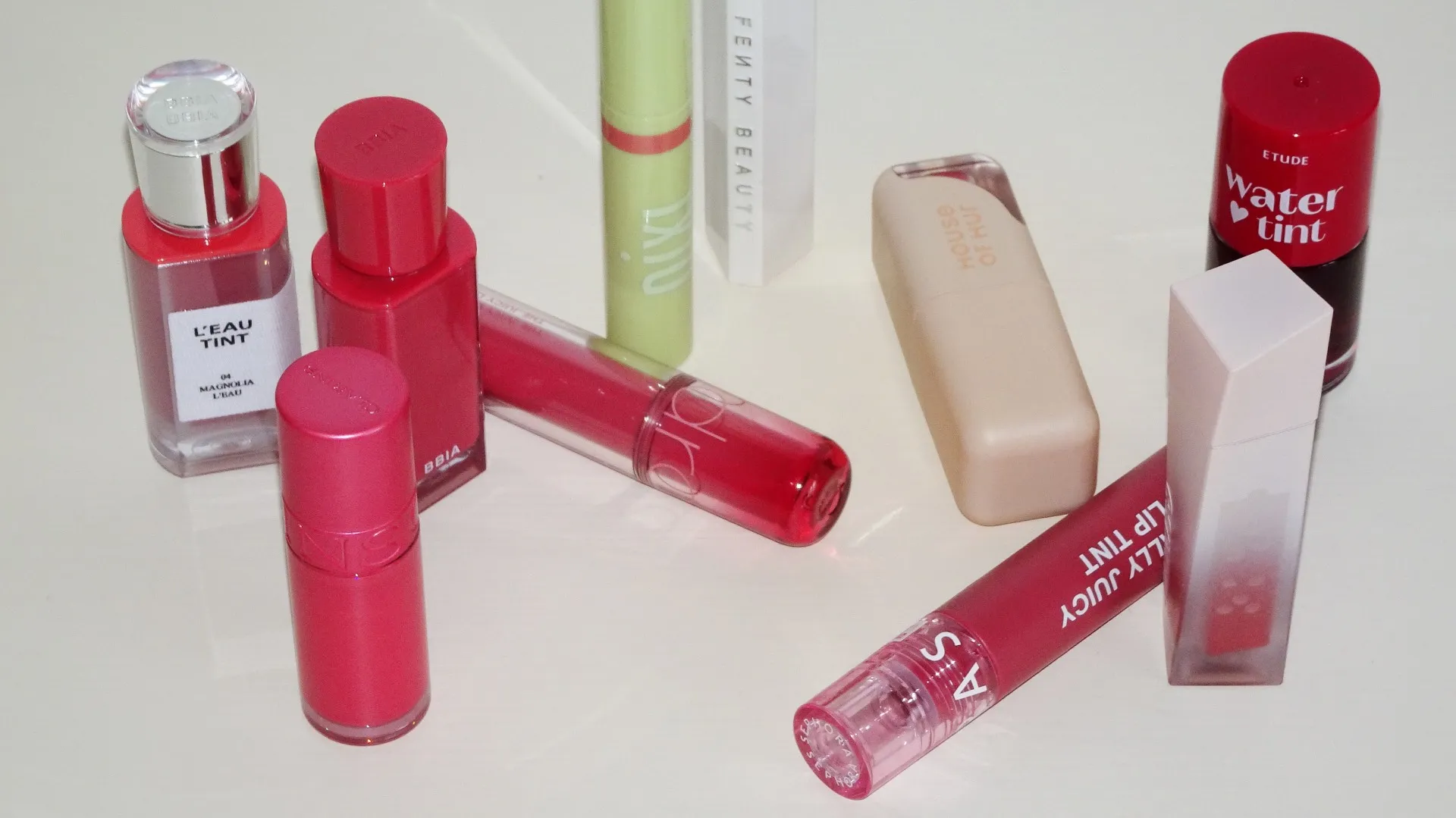 Lip tints, bäst i test, flera lip tints och lip stains utspridda på vit bakgrund, bland annat från BBIA, Pixi, Clarins och Spehora men också testvinnaren från Fenty Beauty