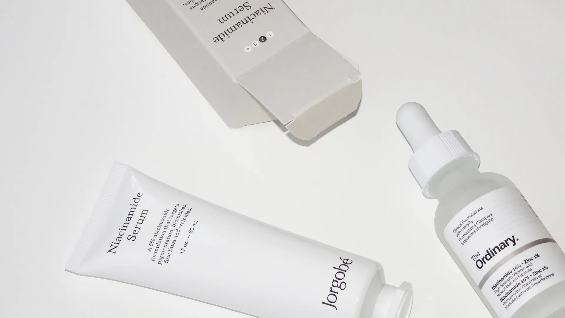 Två olika Niacinamidserum från Jorgobé och The Ordinary på vit bakgrund.