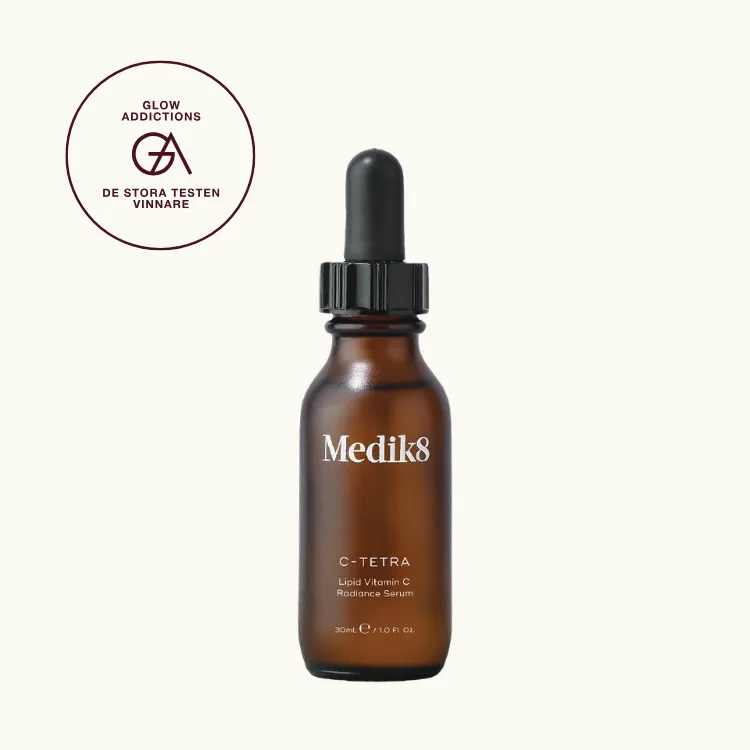 C-vitaminserum, bäst i test: Medik8 C-Tetra, som fick hela 5.00 av 5.00 av Glowaddictions testpanel. Bilden föreställer produkten mot krämfärgad bakgrund, med en ettikett som visar att produkten blev testvinnare.