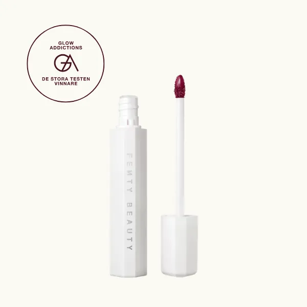 Bäst i test, Lip tints: Fenty Beauty Hydrating Lip Stain Poutsicle, som fick hela 4.00 av Glowaddictions testpanel. Bilden visar ett vitt, sexkantigt hylsa med texten "Fenty Beauty" och ett tillhörande applikatorstift med rosa lip tint på borsten, mot en svart bakgrund.