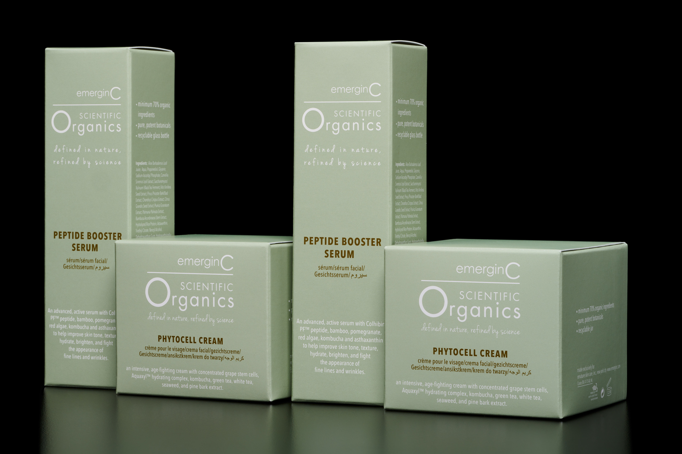 sameFolding carton packaging for emerginC Scientific Organics skincare — sage-green Peptide Booster Serum and Phytocell Cream boxes with white and gold lettering, arranged against a black background.