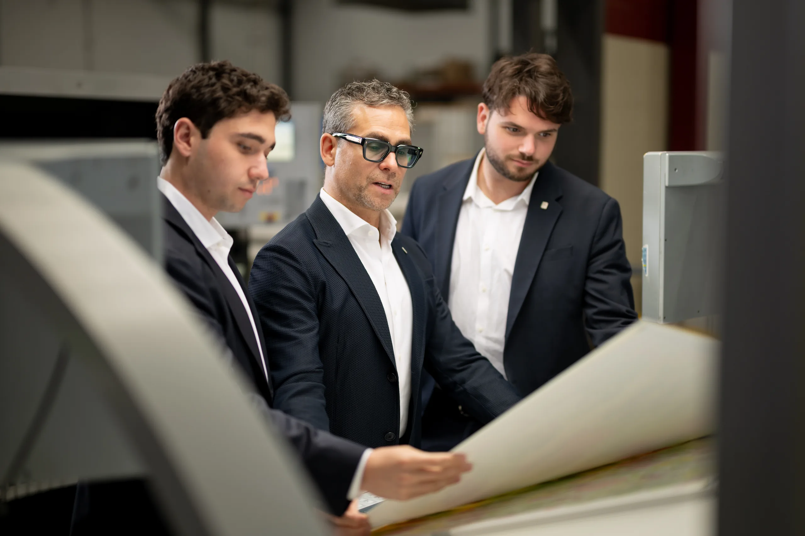 Mich, Josh and Max Kaneff inspecting a large-format print on the Arkay production floor