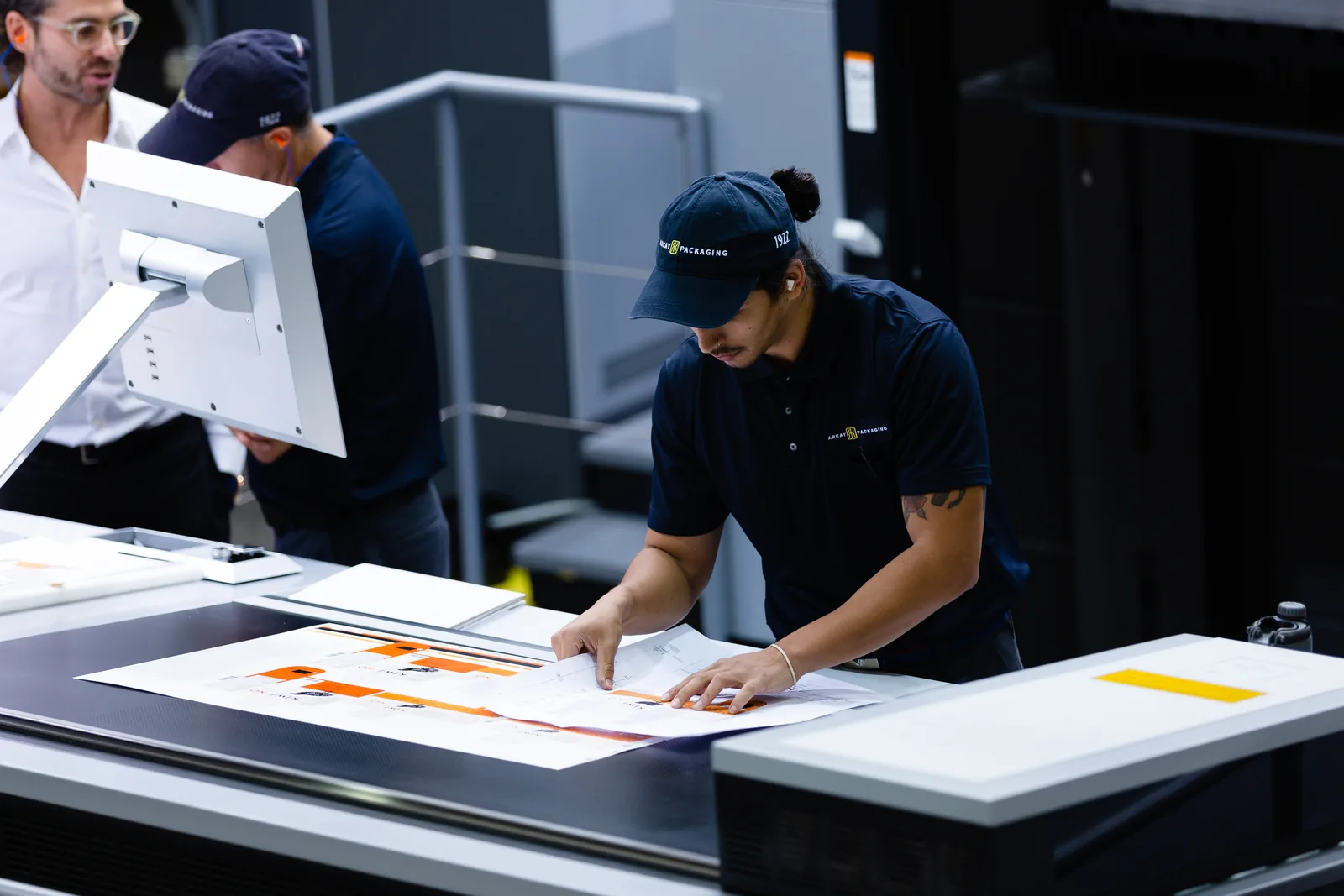 Team reviewing a printed packaging proof sheet at Arkay's facility