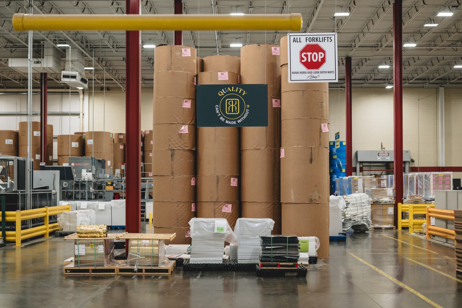 Paperboard reels stacked beside gold foil rolls in Arkay's Roanoke substrate store.
