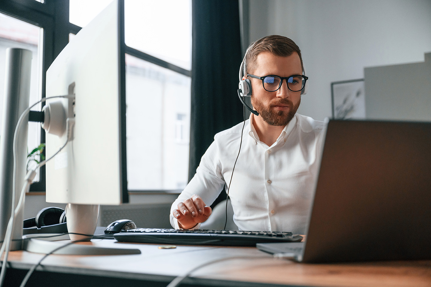 Enterprise IT manager reviewing remote help desk software comparison on dual monitors in a corporate operations center